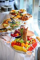Colorful buffet spread at an event. Delicious buffet featuring a variety of fresh fruits, salads, and appetizers, beautifully arranged for guests to enjoy.