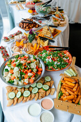 Catering buffet filled with fresh dishes. A vibrant buffet showcases a variety of fresh salads,...