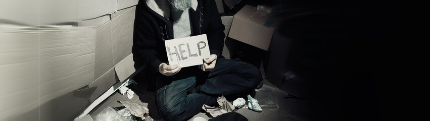 A homeless bearded man sits on boxes on the street and asks for help. Need a homeless person asks...