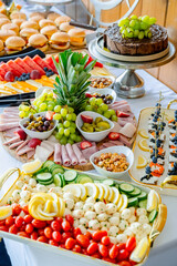 Tasty buffet spread!. An array of fresh fruits, meats, cheeses, and desserts displayed beautifully on a buffet table for guests to enjoy.