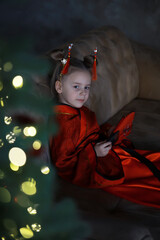Child in Red Traditional Costume with Hair Accessories by Holiday Lights