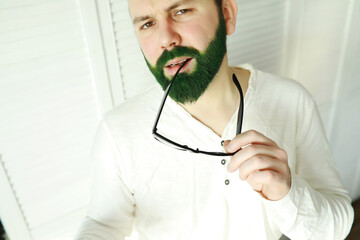 A man with a green beard. St.Patrick 's Day. Irish fan color beard.