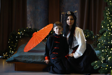 Traditional Chinese Attire with Red Umbrella - Woman and Boy Celebrating in Holiday Decor