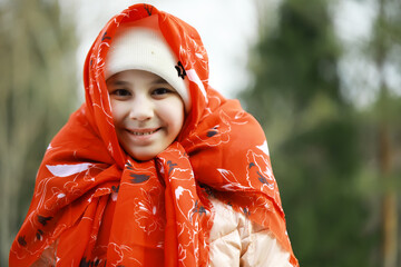 Smiling Girl Wrapped in Red Scarf Outdoors During Wintertime