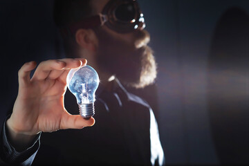 A bearded man in a suit holds an object in his hand. Concept of time and ideas. Aspiration and development.
