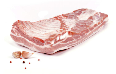 Surowy boczek wieprzowy i dwa ząbki czosnku na białym tle