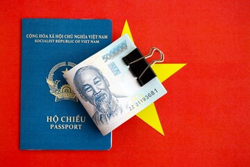 Vietnamese dong currency money bills and passport lies on flag. The concept of travel and vacation