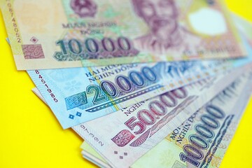 Vietnamese dong money bills in big amount on yellow. Finance and banking concept