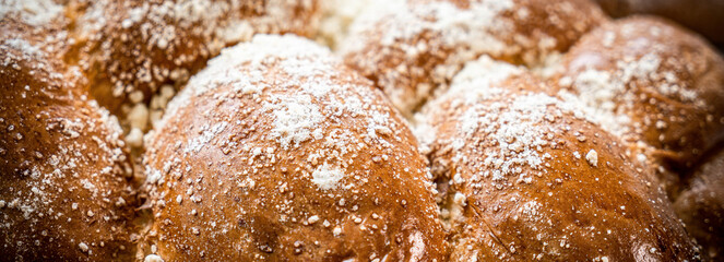 Assortment of fresh baked bread and buns on wooden table background, top view