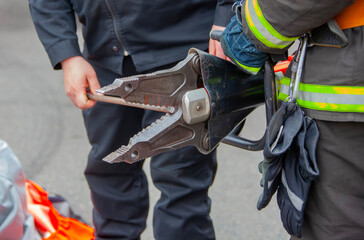 Firefighters using hydraulic rescue tools during an emergency response in a city setting to save...