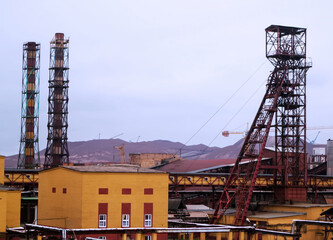 Industrial site with tall structures and machinery during overcast weather in a mining area