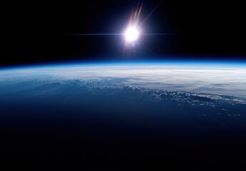 Earth from space, sun rising.  Vast expanse of dark space, a bright sun at horizon.  Earth's blue and white clouds, atmosphere visible