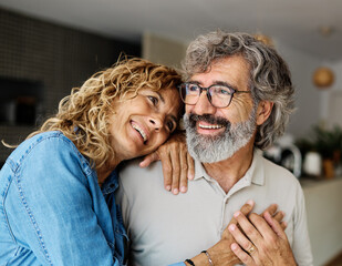 Portrait of a happy senior couple embracing hugging and bonding at home