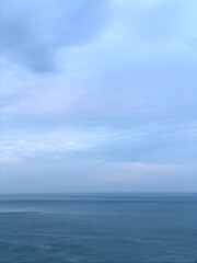 Obraz premium Calm seascape with soft blue sky and horizon.