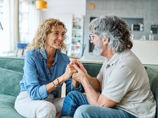 Portrait of a happy senior couple embracing talking at home