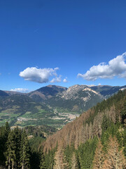 Fototapeta premium Mountain town surrounded by green valley and rocky peaks
