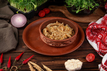 Tender braised tripe cooked with onion and spices served in rustic clay bowl on wooden table authentic homemade dish
