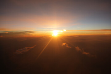 Aerial View From Airplane Window - September 5 2025: Golden sunset over clouds viewed from a plane window during a scenic flight.