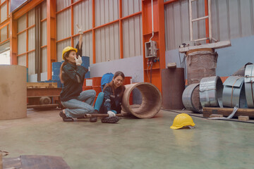 A female worker helps her friend who had a leg accident in a metal cheese factory.