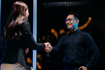 Professional business handshake at night with city lights fostering collaboration success and corporate growth