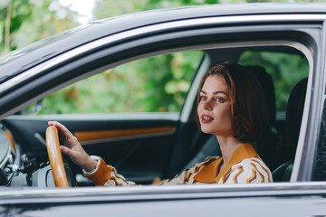 Car, driver, woman, smile a cheerful woman sits inside the car, hands on the steering wheel, calm...