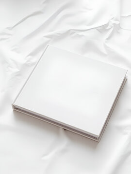 Libro blanco cerrado sobre superficie lisa y clara.