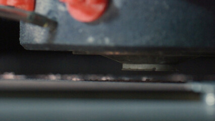 Close up of a 3d printer extruder depositing molten plastic filament onto a build platform, creating an object layer by layer in an additive manufacturing process