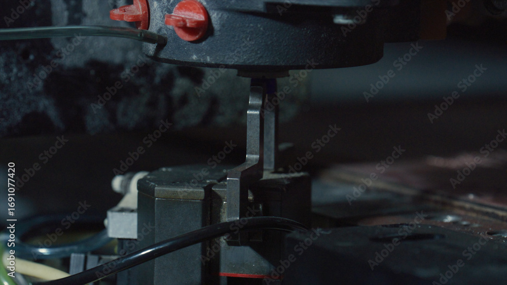 Poster close up view of a robotic arm executing precise tasks in a dimly lit industrial environment, highli