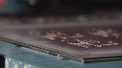 Industrial laser engraving machine etching a metal plate creating a precise and intricate design in...