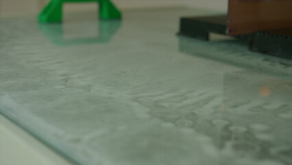 Laser engraver operating on a glass surface, meticulously etching a detailed image with a focused...