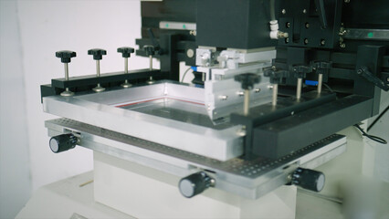 Screen printing machine applying ink to fabric in a modern workshop, showcasing the precision and automation of textile printing technology