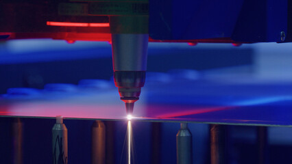 Automated industrial laser precisely cutting a metal sheet in a modern factory, showcasing advanced manufacturing technology and precision engineering