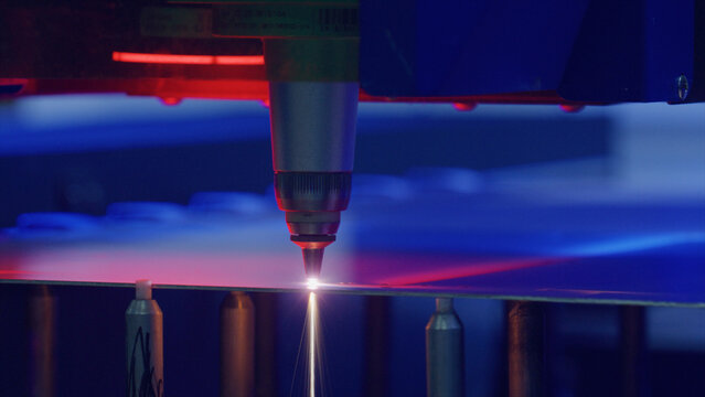 Automated industrial laser precisely cutting a metal sheet in a modern factory, showcasing advanced manufacturing technology and precision engineering