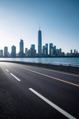 Naklejka premium 青空の下アスファルトの道と高層ビル群の都市景観 青い海の背景にそびえ立つ近代的な都市風景