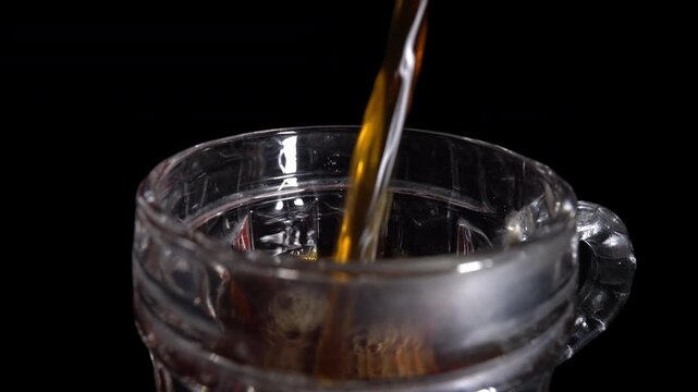 Pouring Fresh Black Coffee Into Transparent Glass Cup on Dark Background