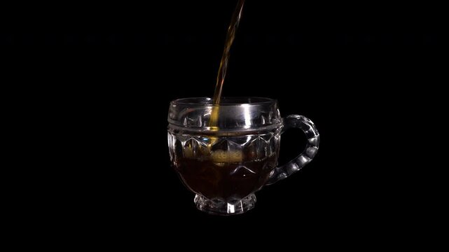 Pouring Fresh Black Coffee Into Transparent Glass Cup on Dark Background