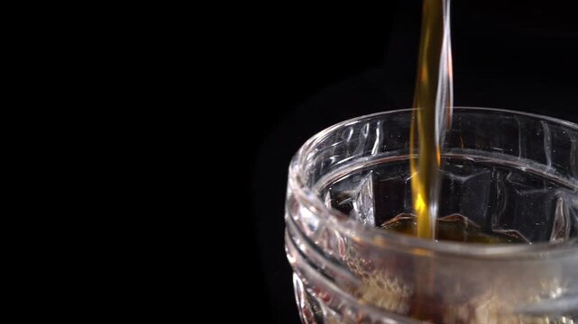 Pouring Fresh Black Coffee Into Transparent Glass Cup on Dark Background