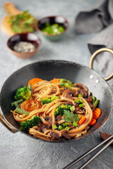 Wok noodles with mushrooms, broccoli, carrots and green onions.