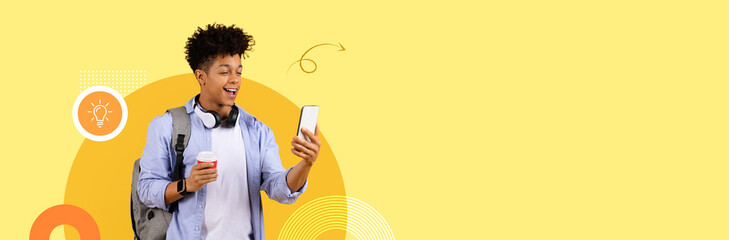 A student stands with a smartphone in one hand and a coffee cup in the other, smiling as they...