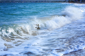 Ocean waves crashing on sandy beach. Sea waves breaking on shore. Nature splash on summer day. Sea wave crashing on beach. Splashing sea water with foam.