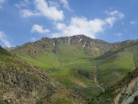 Top of a Mountain with Patches of Snow against Blue Sky with Clouds in the Gissar (Hisar) Mountain Range in Uzbekistan