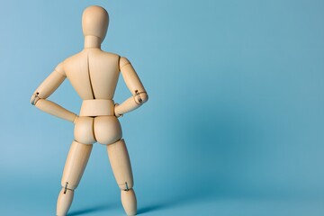 Wooden mannequin showcasing posture against a pale blue minimalist background