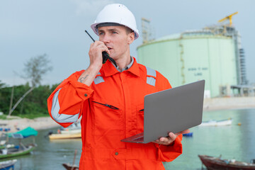 Engineer at LNG Facility Holding Laptop