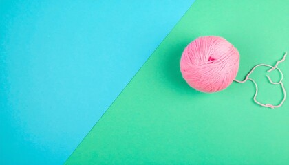 Pink yarn ball on a teal and mint background
