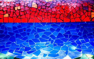 muro recubierto de cerámica con forma geométrica de colores rojo en la parte de arriba y azul...