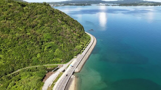 Forward aerial view approaching Kouri Island via Warumi Bridge over turquoise sea Okinawa Japan