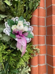Ranke am Eingang zur Kirche mit kleinem Blumenstrau&szlig;, liebevoll arrangiert bei einer Hochzeit