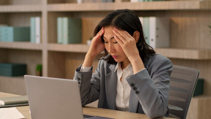 Stressed tired businesswoman frustrated Asian chinese japanese korean woman business girl anxious exhausted worker online work laptop computer in office crisis bankrupt crash failure overwork headache
