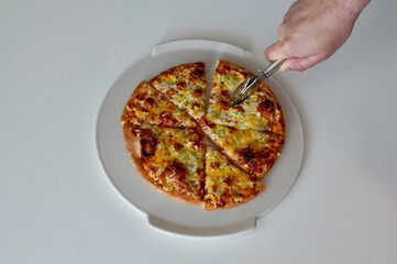 Pizza on a white plate with a knife. White background.