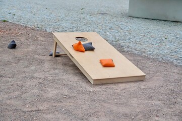 Wooden bench with orange cushions on the ground in the park